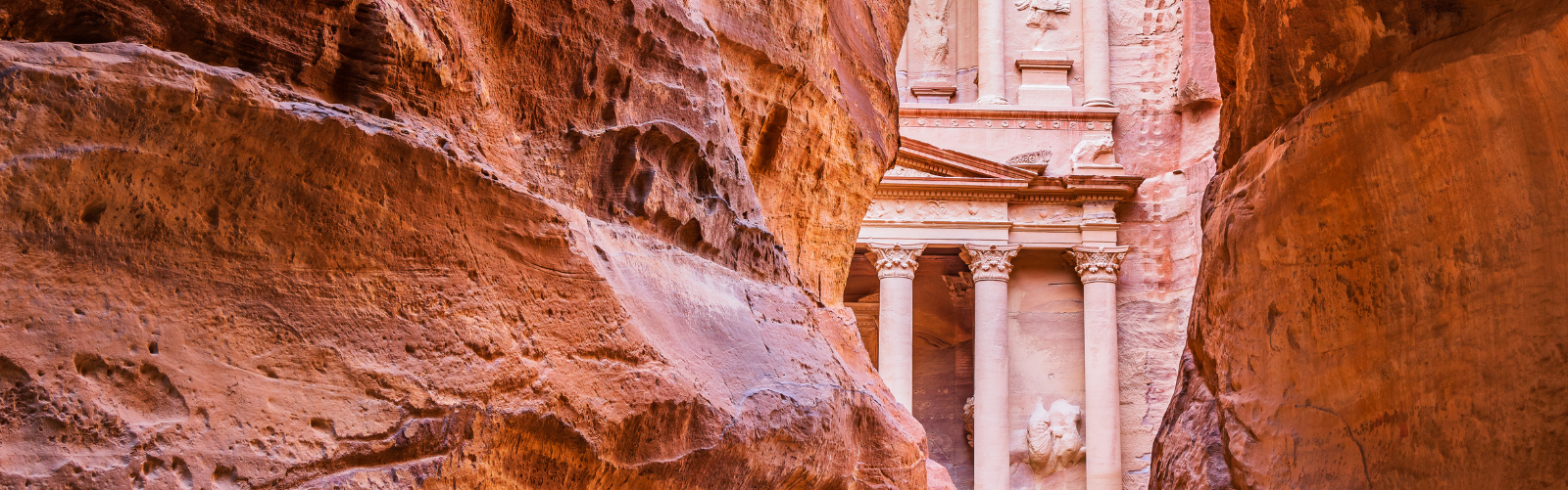 The Treasury structure at Petra in Jordan viewed through a narrow canyon of red rock